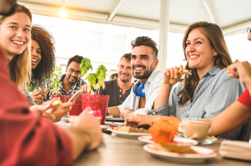 Menschen sitzen bei Getränke & Essen zusammen und plaudern